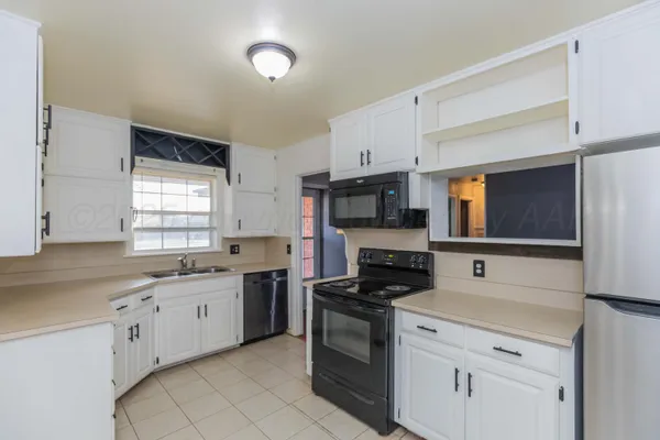 a kitchen with granite countertop a sink stainless steel appliances and cabinets