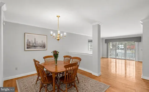a dining room with furniture a chandelier and wooden floor