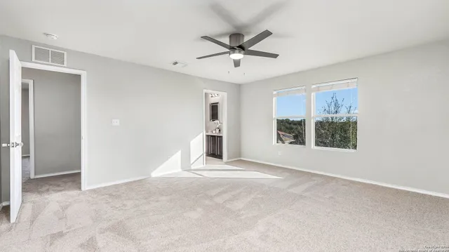 a view of a livingroom with a ceiling fan and windows