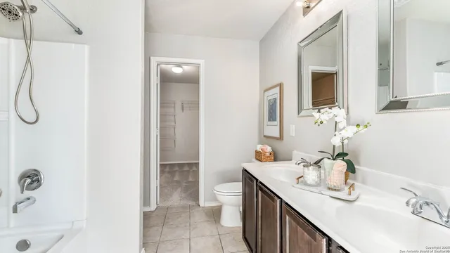 a bathroom with a granite countertop sink a toilet and shower