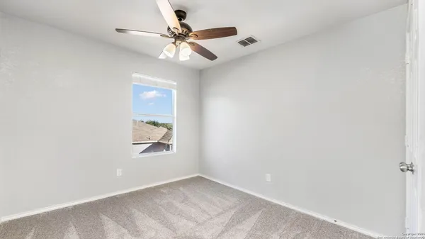 an empty room with window and fan
