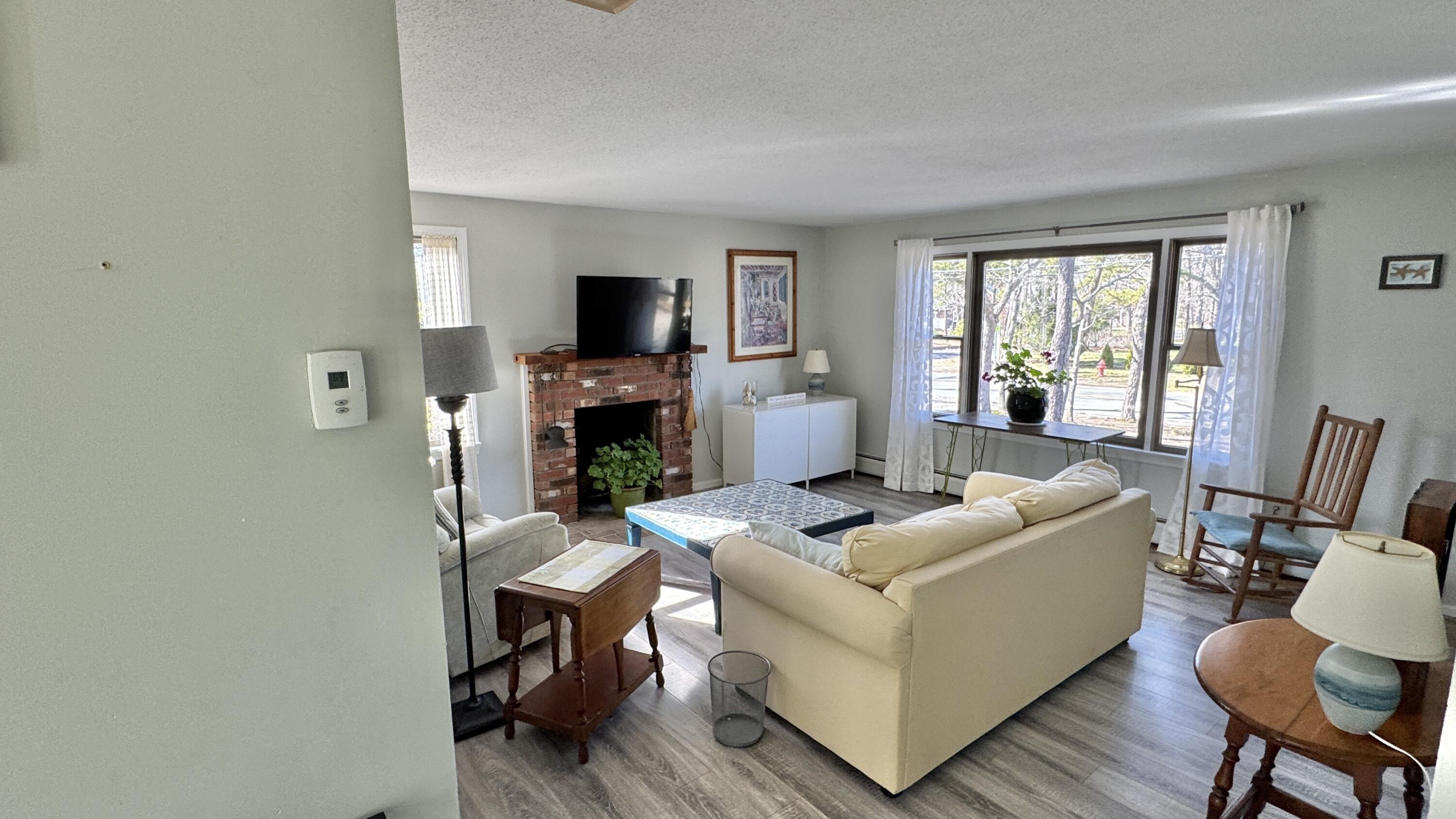 300 Brackett Road Eastham, MA 02642 - Photo 11 of 30 a living room with furniture a flat screen tv and a fireplace