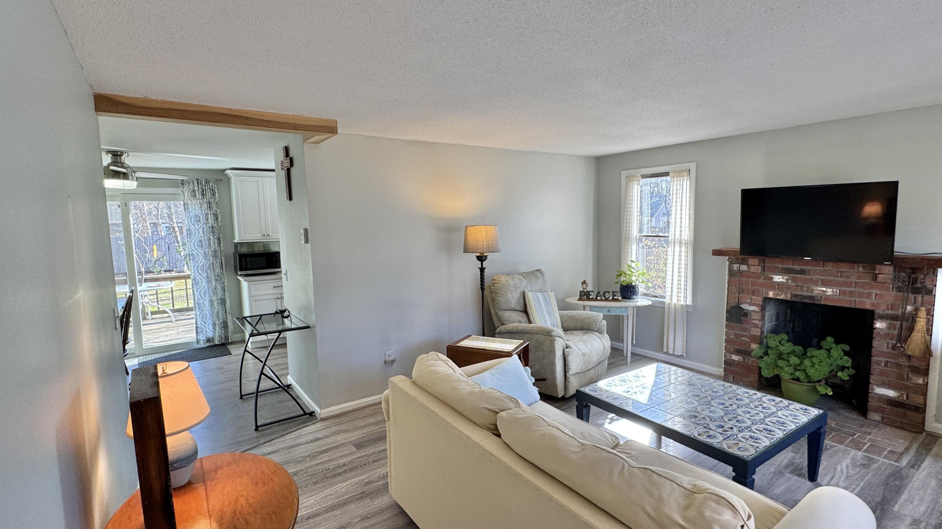 300 Brackett Road Eastham, MA 02642 - Photo 14 of 30 a living room with furniture a fireplace and a flat screen tv