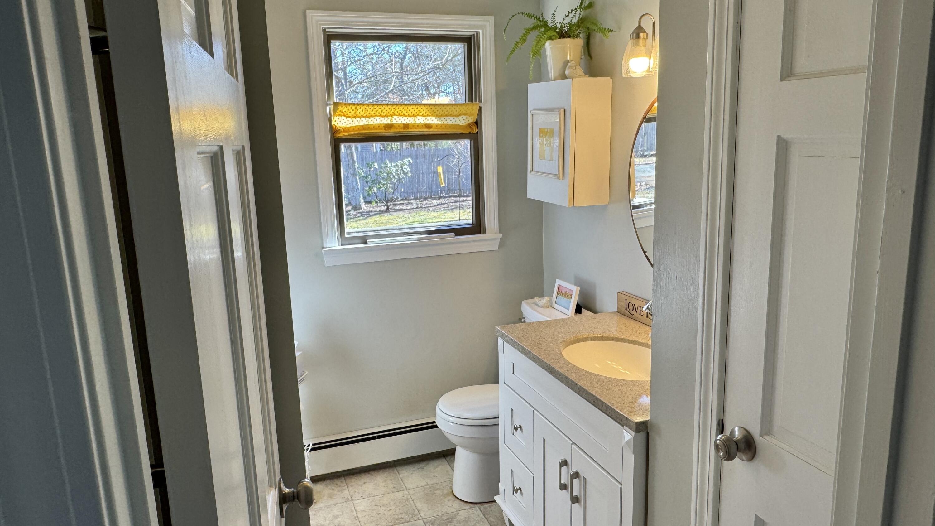 300 Brackett Road Eastham, MA 02642 - Photo 19 of 30 a bathroom with a granite countertop toilet a sink and a mirror