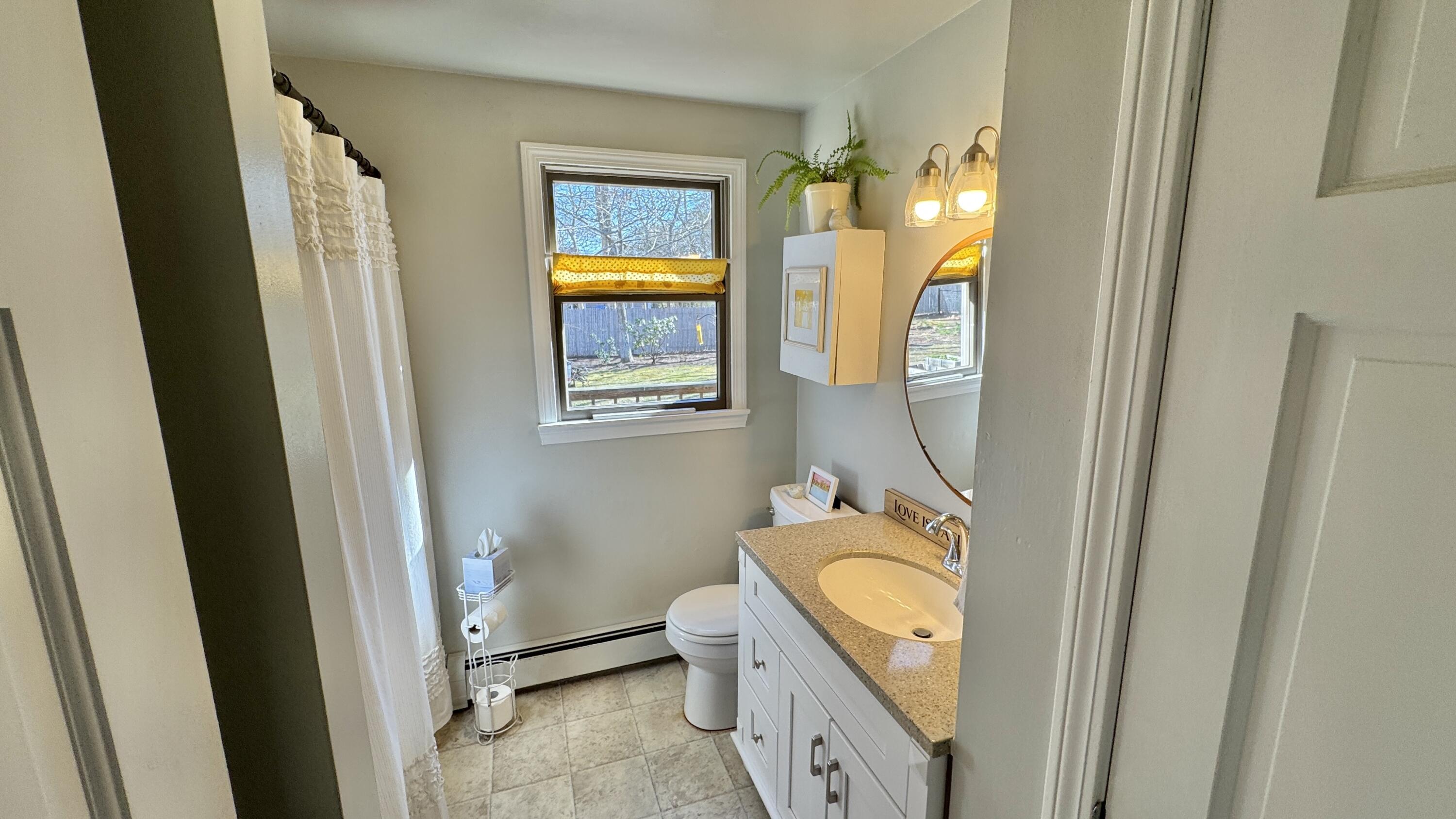 300 Brackett Road Eastham, MA 02642 - Photo 20 of 30 a bathroom with a granite countertop toilet sink and mirror
