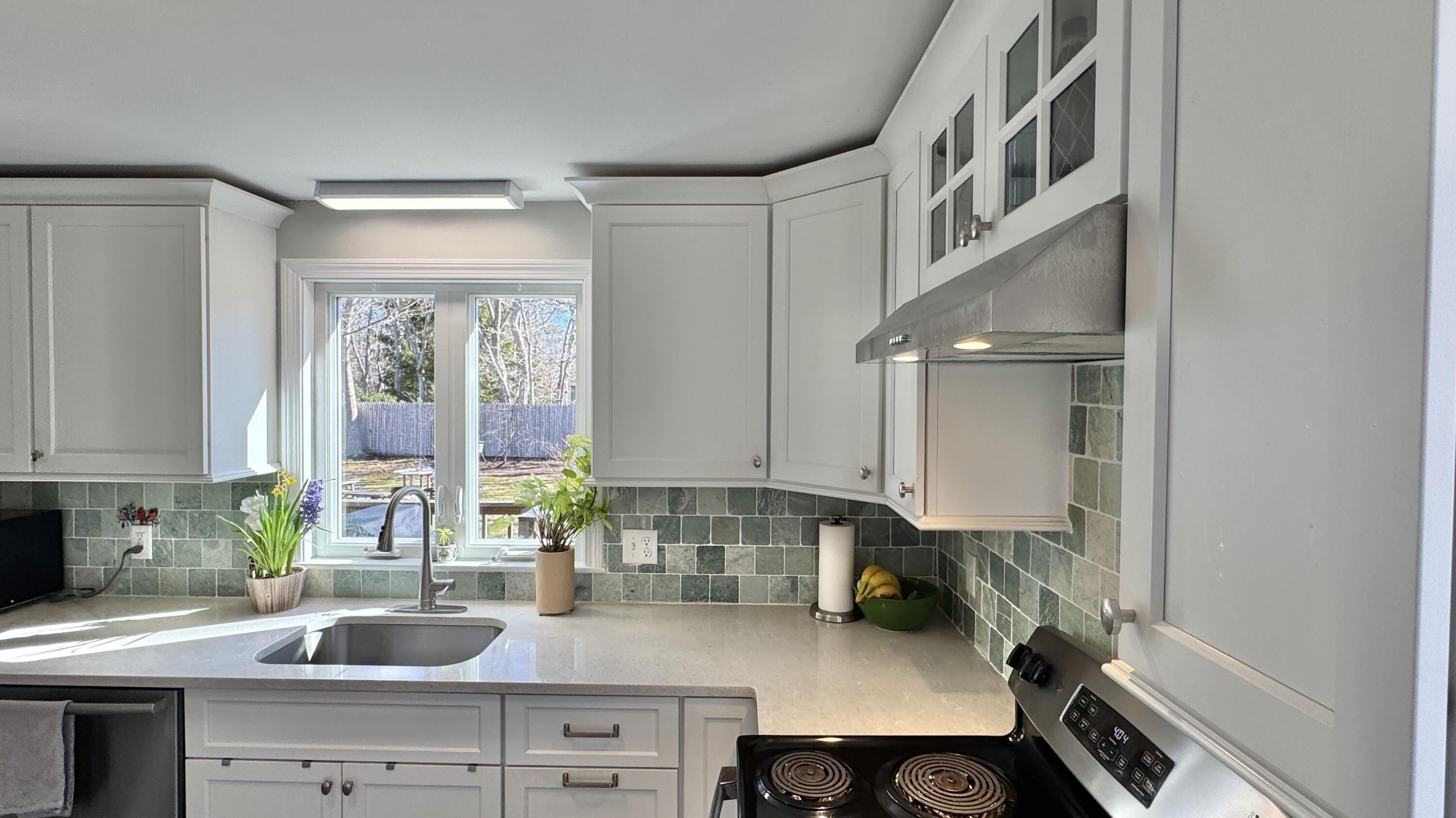 300 Brackett Road Eastham, MA 02642 - Photo 7 of 30 a kitchen with a sink stove and cabinets