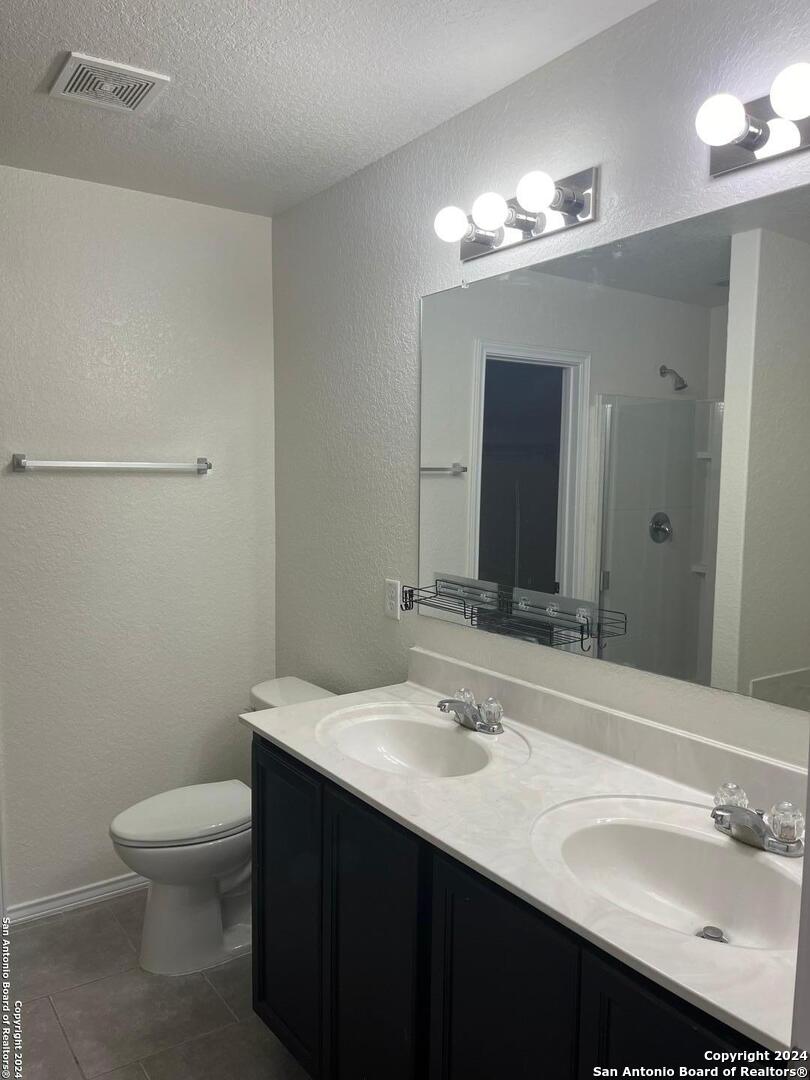 803 Roping Horse San Antonio, TX 78260 - Photo 7 of 18 a bathroom with a sink a toilet a light fixture and mirror