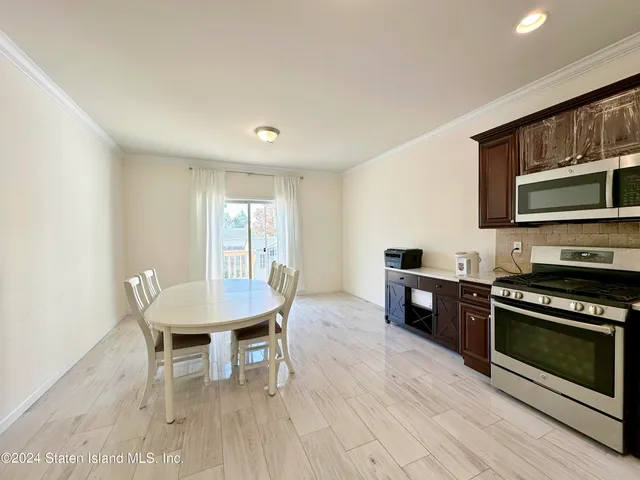 a living room with furniture a flat screen tv and kitchen view