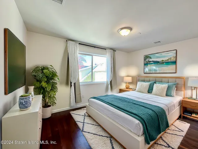 a bedroom with a large bed and a potted plant