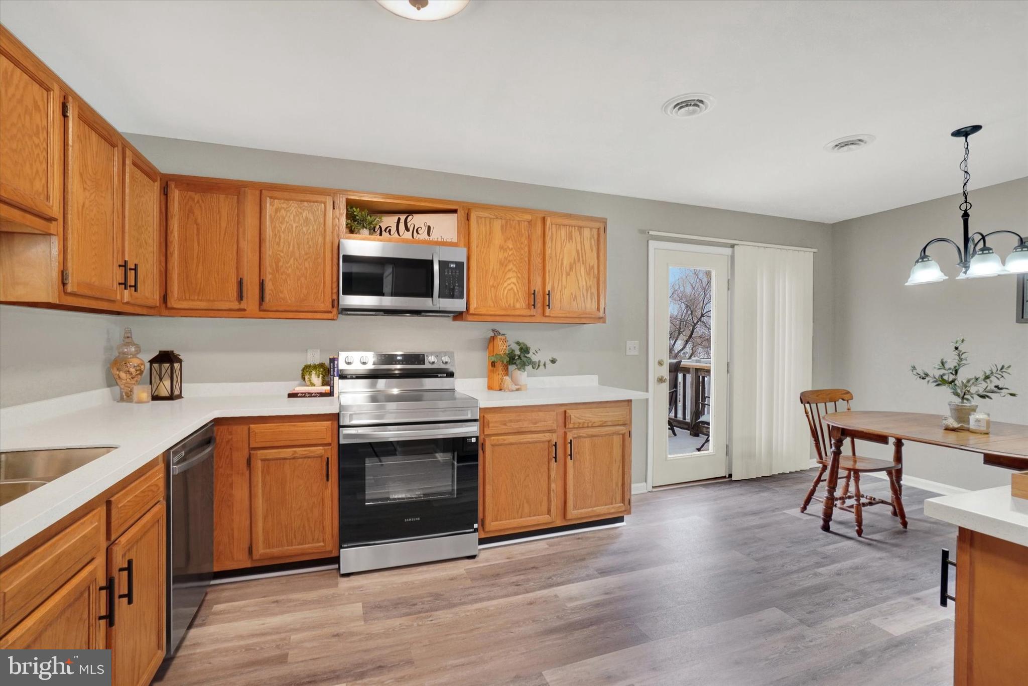 1606 Condor Lane Dover, PA 17315 - Photo 5 of 28 a kitchen with stainless steel appliances granite countertop a stove top oven a sink dishwasher and a refrigerator with wooden cabinets