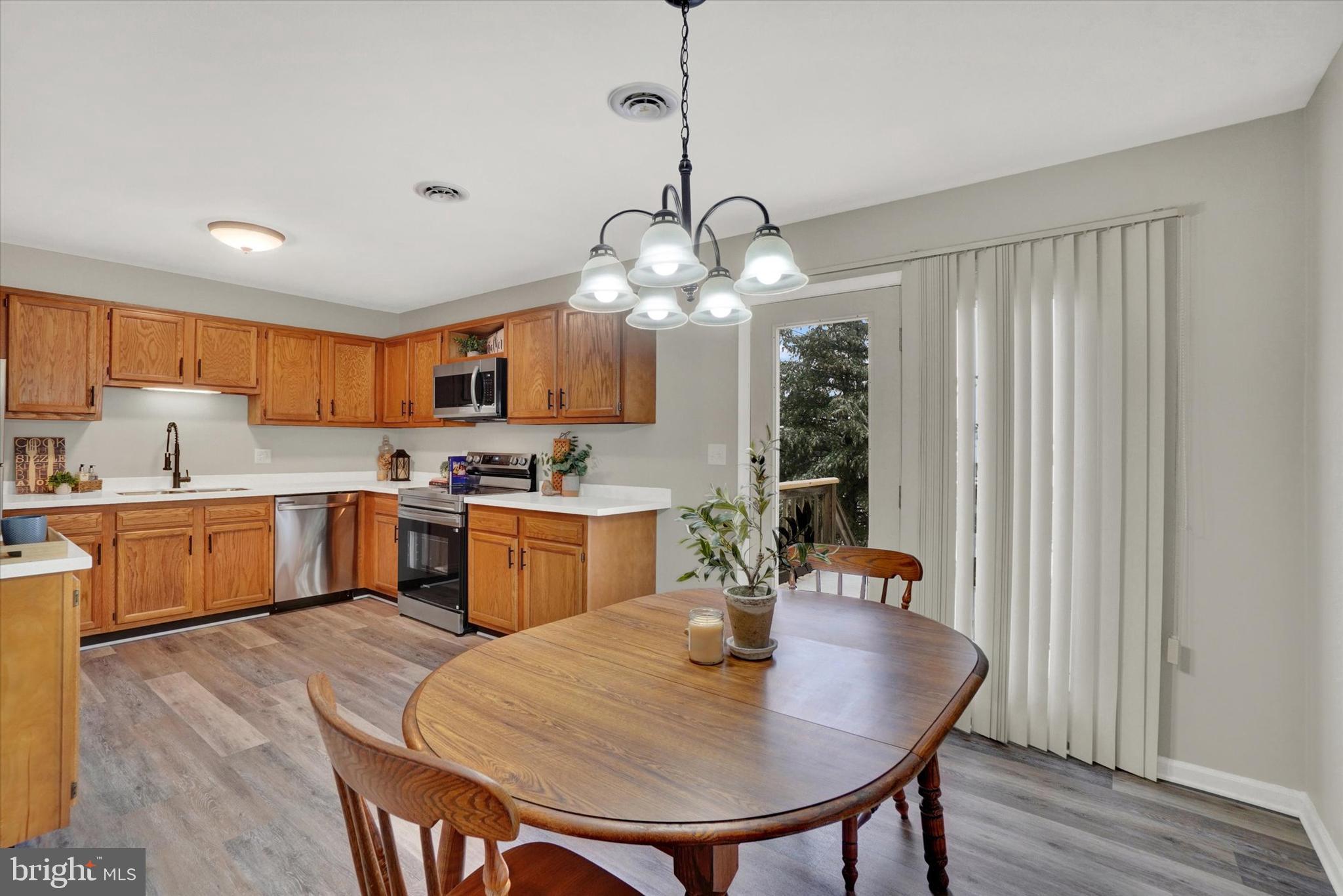 1606 Condor Lane Dover, PA 17315 - Photo 7 of 28 a kitchen with sink refrigerator dining table and chairs