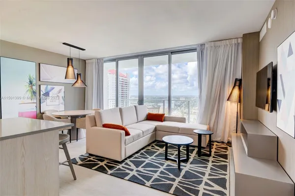 a living room with furniture a large window and a flat screen tv