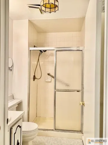 a bathroom with a granite countertop shower sink vanity and toilet