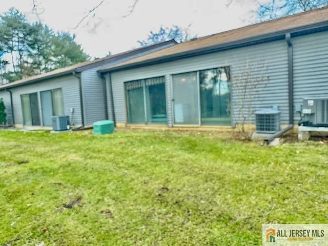 a backyard of a house with large trees and plants