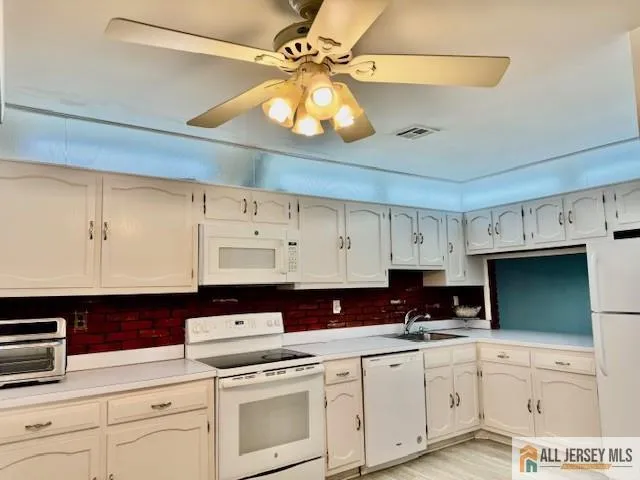 a kitchen with cabinets appliances a sink and a counter top space