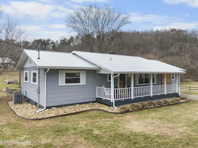a view of a house with a yard and wooden fence