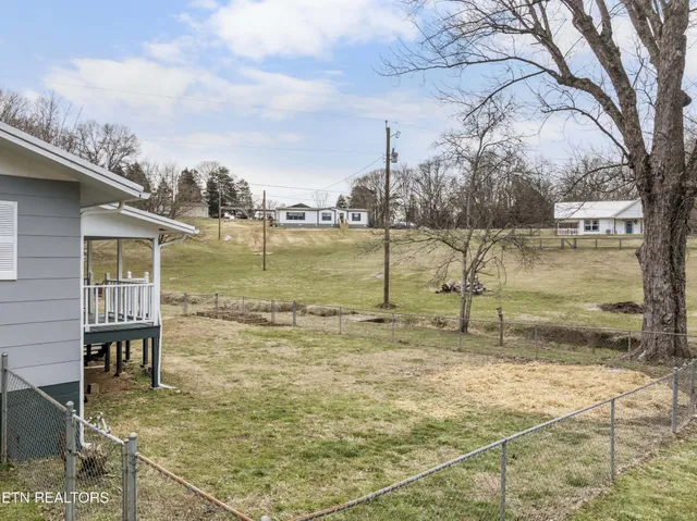 a backyard of a house with wooden deck and barbeque oven