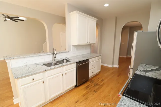 a kitchen with granite countertop a refrigerator stove and microwave