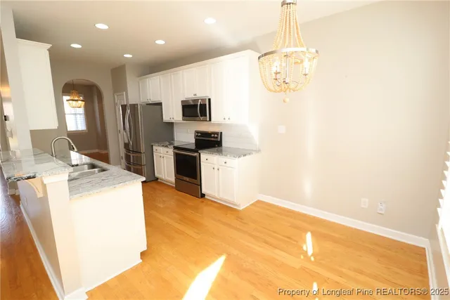 a large kitchen with kitchen island a stove a sink a counter space and cabinets