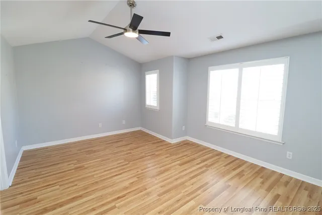 a view of a big room with wooden floor and a ceiling fan