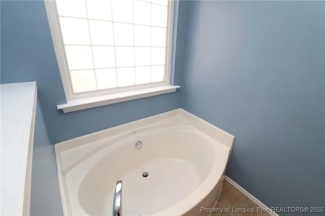 a bathroom with a bathtub sink and mirror