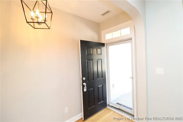 a view of empty room with wooden floor and windows