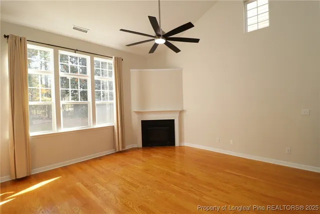 a view of an empty room with a fireplace and a window