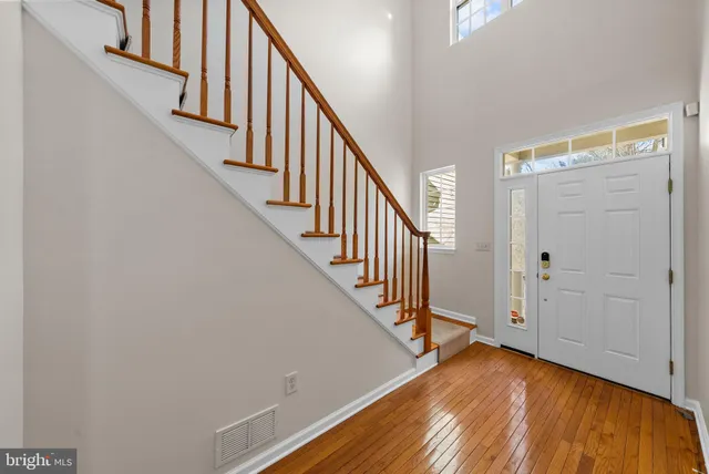 a view of front door with wooden floor and stairs