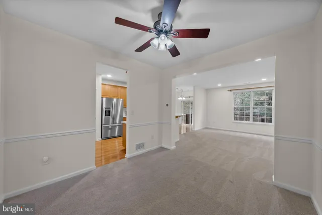 en empty room with windows and fan