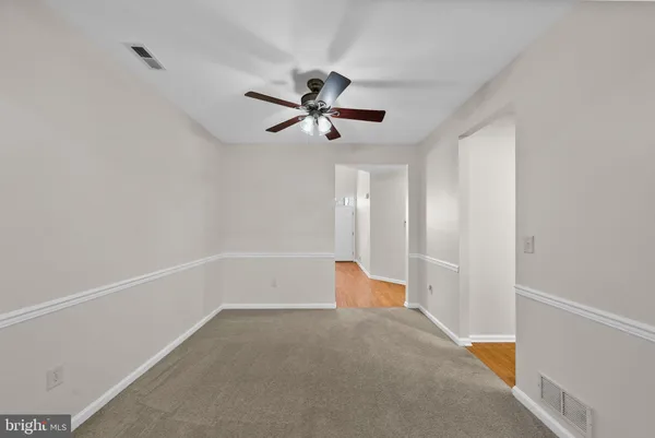 a view of a livingroom with a ceiling fan and hardwood floor