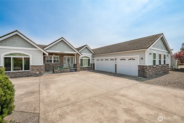 a front view of a house with a large window and garage
