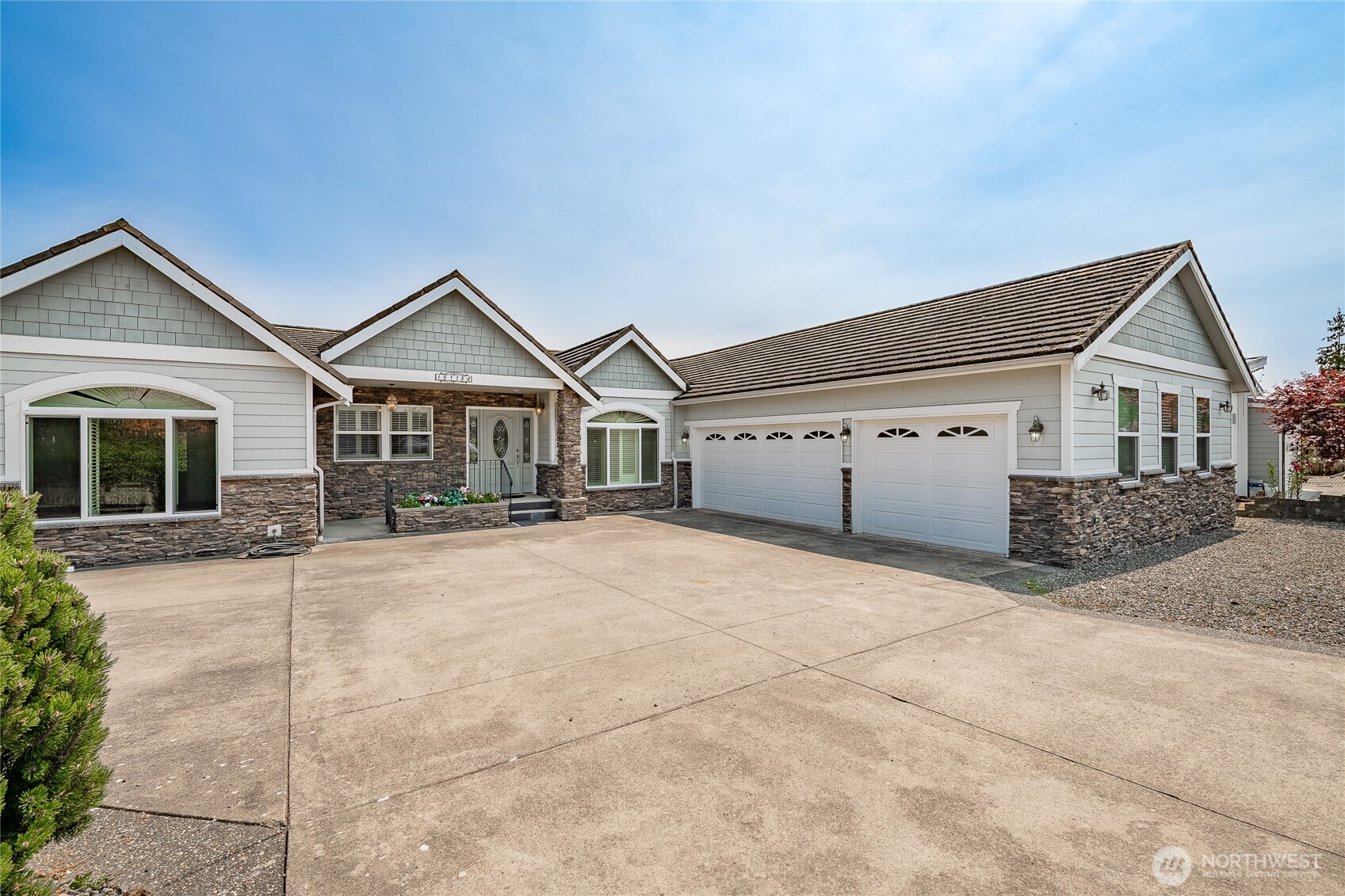 a front view of a house with a large window and garage