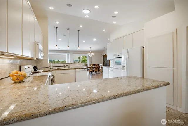 a kitchen with stainless steel appliances granite countertop a sink refrigerator and cabinets