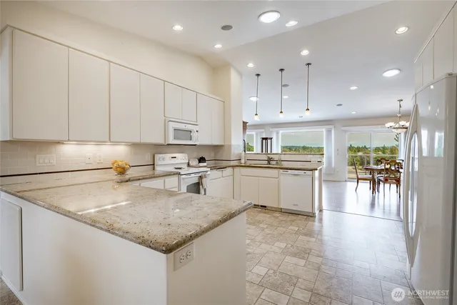 a kitchen with a white center island a sink a stove and cabinets