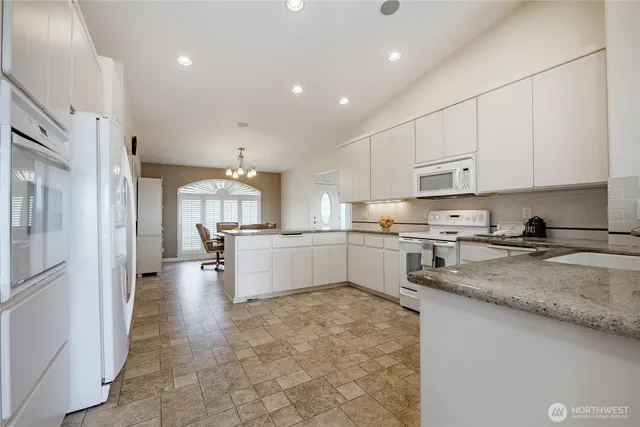 a kitchen with stainless steel appliances granite countertop a refrigerator sink and cabinets