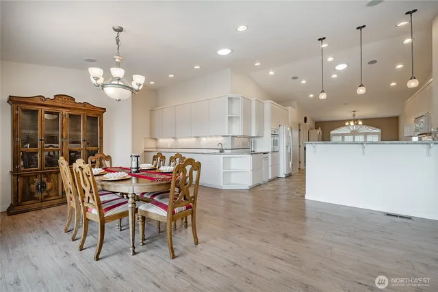 a dining room filled chandelier and wooden floor