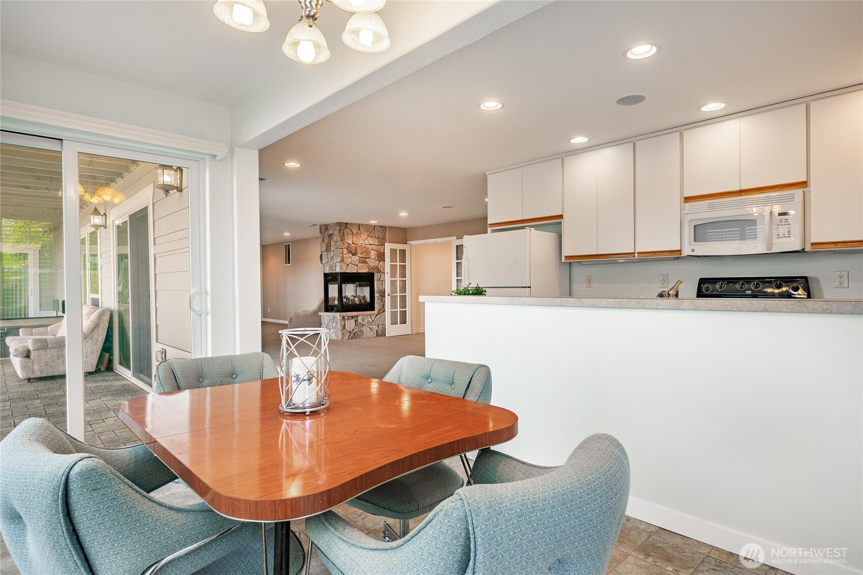 8118 Comox Road Blaine, WA 98230 - Photo 38 of 40 a kitchen with stainless steel appliances kitchen island granite countertop a dining table chairs and a refrigerator