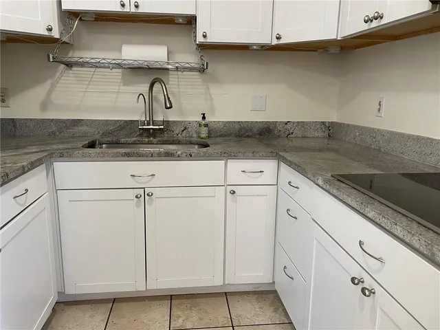 a kitchen with granite countertop white cabinets and white appliances