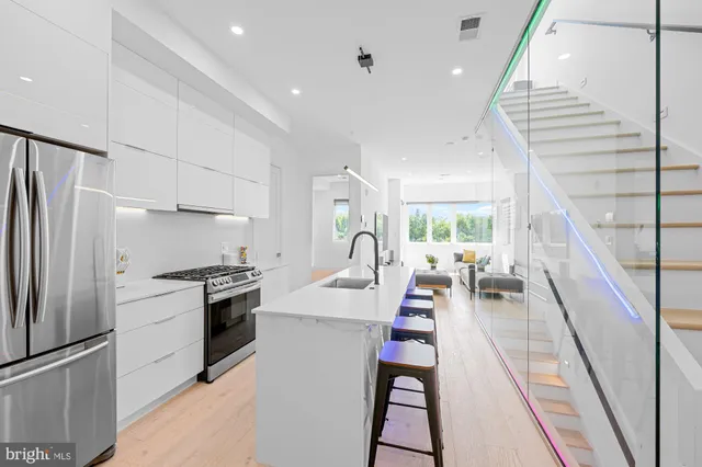 a kitchen with kitchen island white cabinets and stainless steel appliances