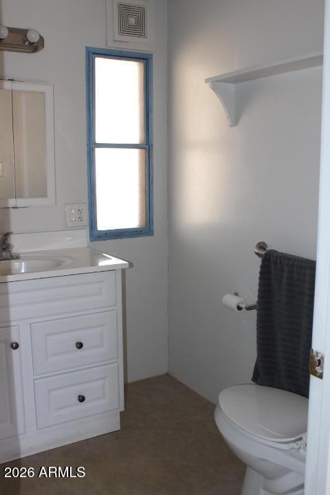 303 South Recker Road, Unit 128 Mesa, AZ 85206 - Photo 19 of 26 a bathroom with a toilet a sink a vanity and mirror