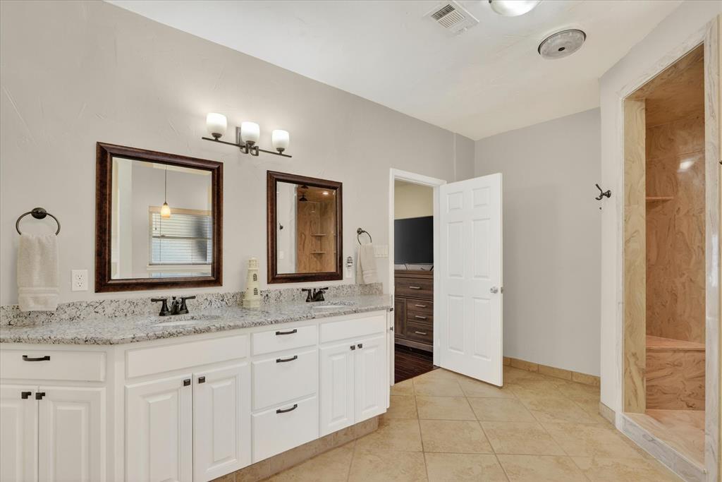 8877 Random Road Fort Worth, TX 76179 - Photo 15 of 40 Dual vanity with granite-style countertops, white cabinetry, and individual framed mirrors