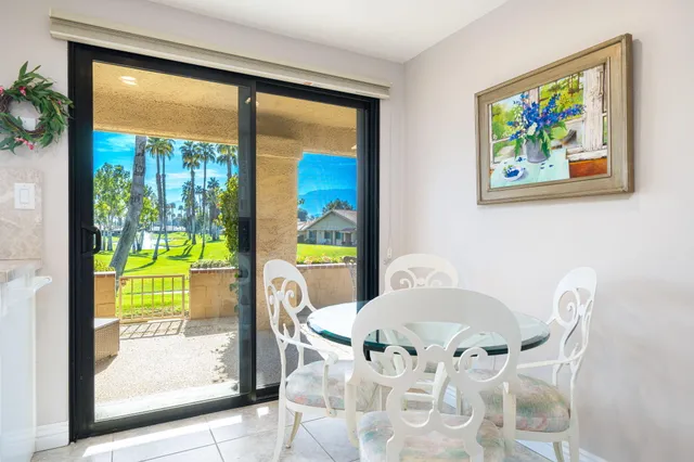 a view of a dining room with furniture a garden view and a large window