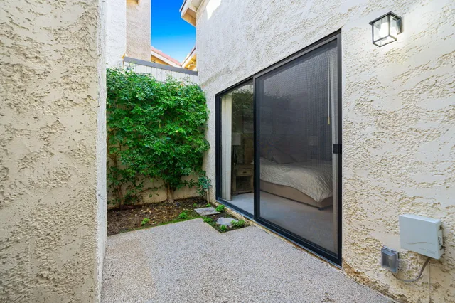 a view of a small yard in front of a house with plants and a garden
