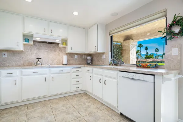 a kitchen with granite countertop white cabinets and white appliances