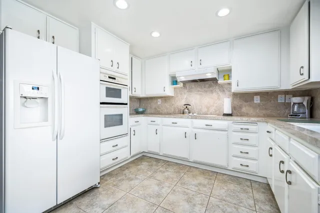 a kitchen with granite countertop cabinets and white appliances