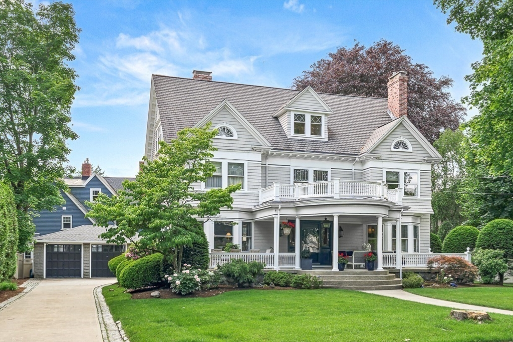 a front view of a house with a yard and trees