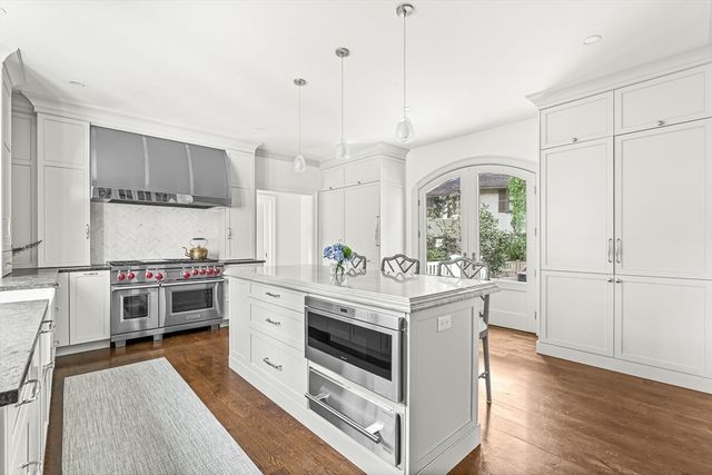 a large white kitchen with a stove and a wooden floors