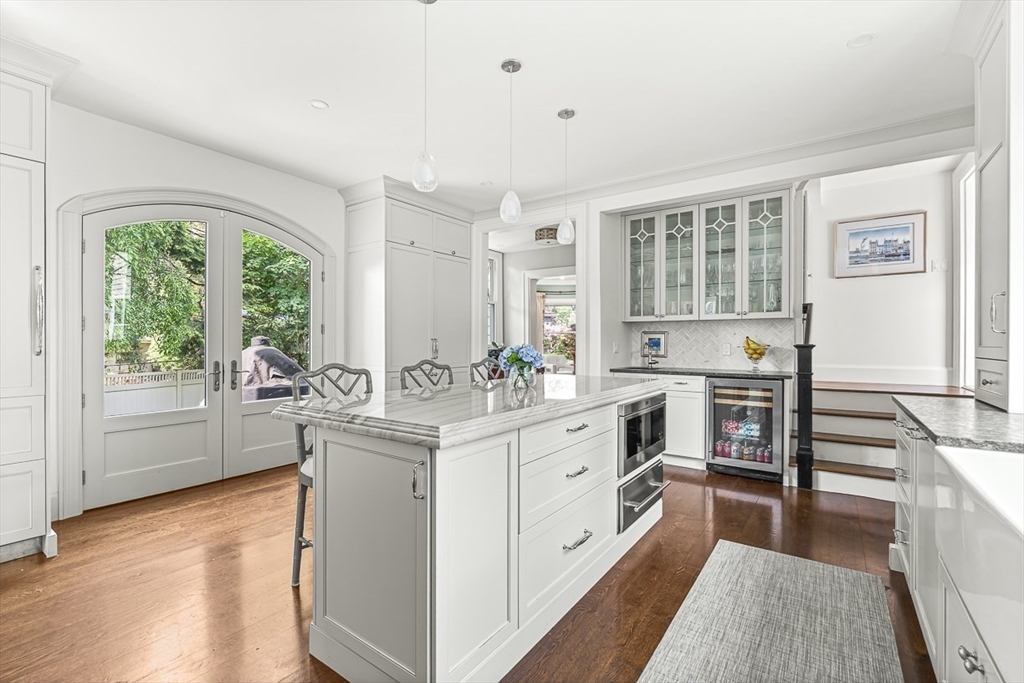 5 Stratford Road Winchester, MA 01890 - Photo 17 of 39 a kitchen with stainless steel appliances granite countertop a stove a sink dishwasher a refrigerator and a dining table with wooden floor