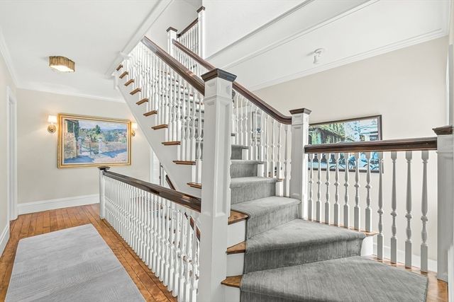 a view of staircase with lots of frames on wall and a window