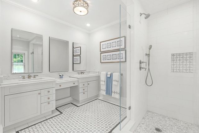 a spacious bathroom with a double vanity sink a mirror a shower and a window